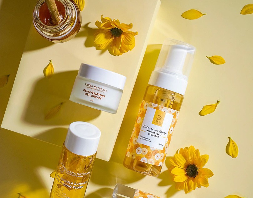 Skincare products on a yellow set with honey and petals