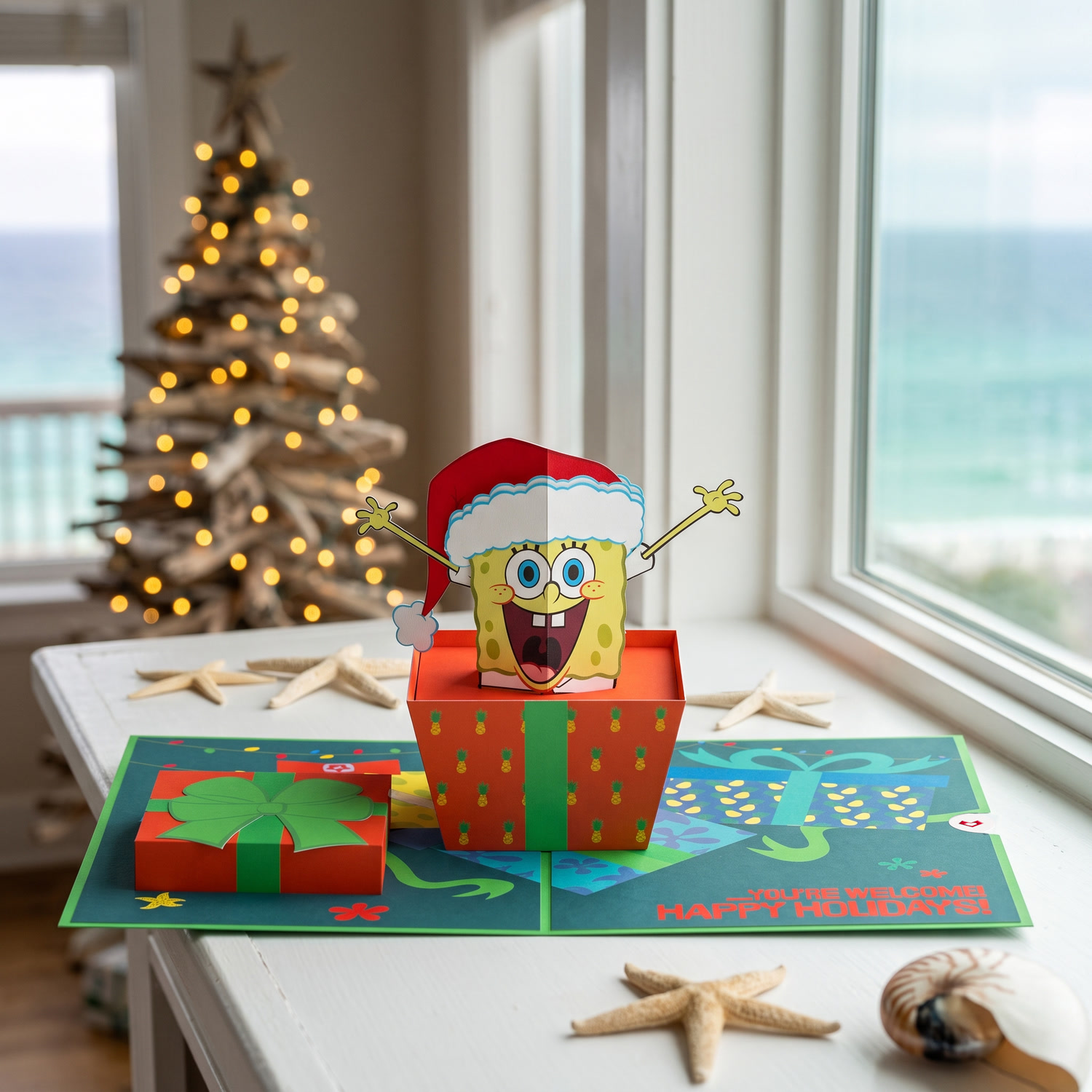 Character pop-up card by a beach window at Christmas
