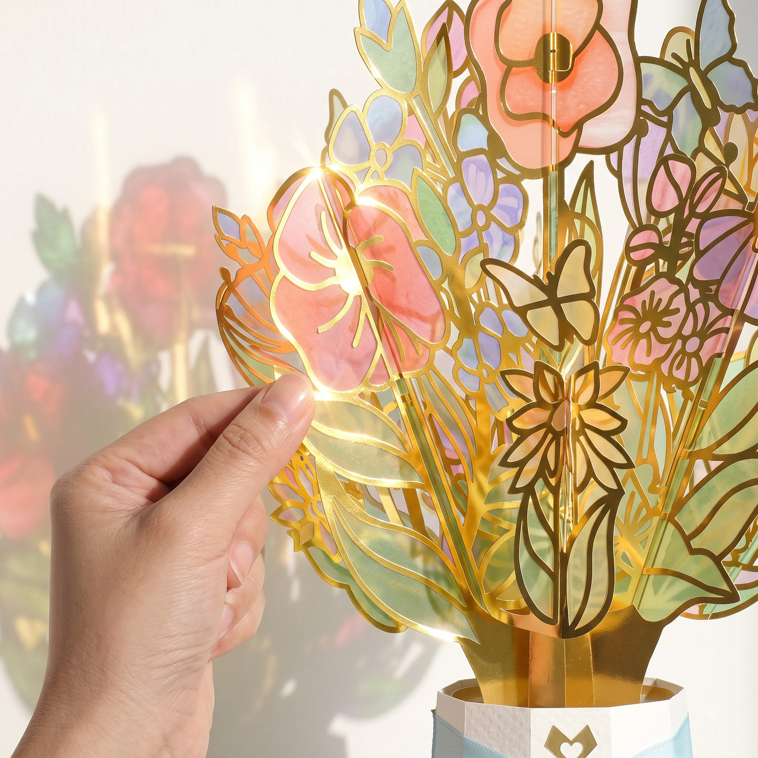 Gold foil paper flower bouquet held up to backlight